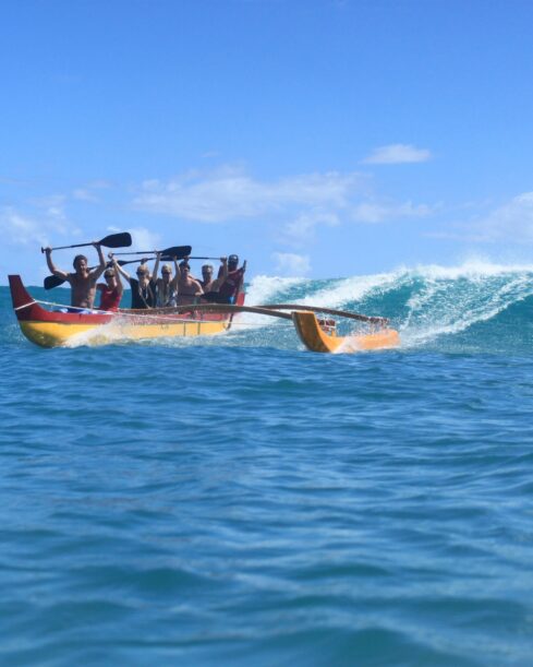 Tourists enjoy the Hawaiian sport of outrigger surfing