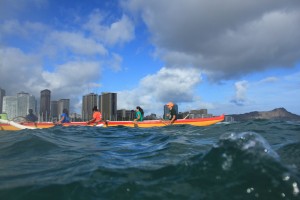 A team of outrigger paddlers takes a breath on their final stretch into the Ala Moana channel.