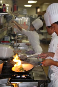 A Saute chef cooks up an order behind the scenes for a customer at Kapiolaniʻs 220 Grille.