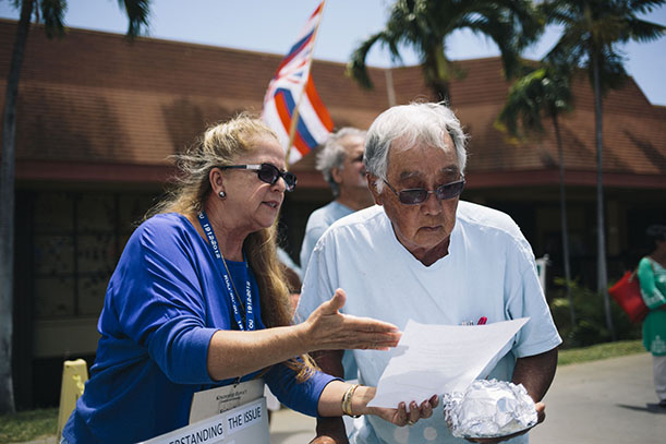 HONOLULU, HAWAII - APRIL 13:  KCC STEM Center Coordinator Keolani Noa goes over a fact sheet listing facts about TMT and Mauna Kea during a protest of the Thirty Meter Telescope in front of the Great Lawn at Kapiolani Community College on April 13, 2015 in Honolulu, Hawaii.